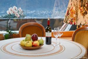 a table with a bowl of fruit and a bottle of wine at Ferienwohnung Spiess in Merano +2 photos