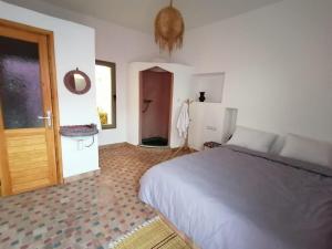 1 dormitorio con cama y puerta con espejo en Villa DAR MAMA, en Essaouira