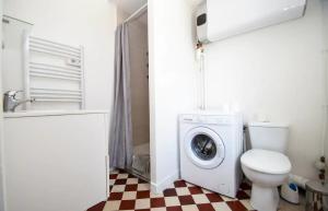 a bathroom with a washing machine and a toilet at Superbe studio 2 pers tout équipé WIFI & Proche Paris - R2 in Montreuil