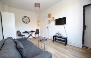 a living room with a couch and a table at Superbe studio 2 pers tout équipé WIFI & Proche Paris - R2 in Montreuil