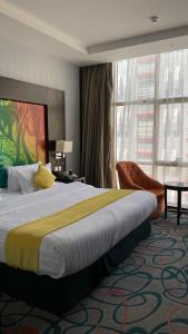 een hotelkamer met een groot bed en een groot raam bij فندق الراحة السويسرية in Jeddah