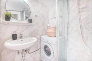 a bathroom with a sink and a washing machine at Koukaki apartment in Athens