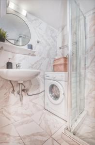 a bathroom with a washing machine and a sink at Koukaki Apartment in Athens