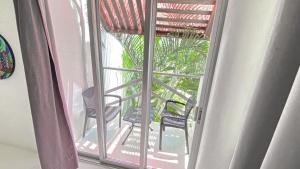 an open door to a balcony with two chairs at Villa Aikia (Adults Suites A/C) in Zipolite