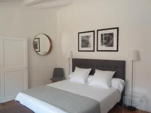 a bedroom with a bed with white sheets and a mirror at Appartement Quartier Mazarin in Aix-en-Provence