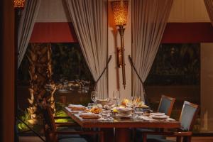 a table with glasses and plates on top of it at Banyan Tree Tamouda Bay in Fnidek