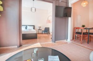 a living room with a glass table and a bedroom at Koukaki apartment in Athens