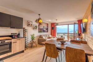 eine Küche und ein Wohnzimmer mit einem Tisch und Stühlen in der Unterkunft Stunning flat with views of Mont Blanc in Combloux - Welkeys in Combloux