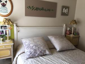 a bedroom with a bed with two pillows on it at CHEZ BEATRICE in Herbignac