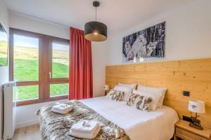 ein Schlafzimmer mit einem Bett mit zwei Handtüchern darauf in der Unterkunft Stunning flat with views of Mont Blanc in Combloux - Welkeys in Combloux