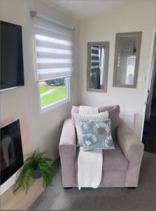 un soggiorno con un divano e una TV di At The Waters Edge ( Wansbeck View 26 ) a Newbiggin-by-the-Sea