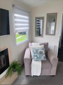 a living room with a couch and a tv at At The Waters Edge ( Wansbeck View 26 ) in Newbiggin-by-the-Sea