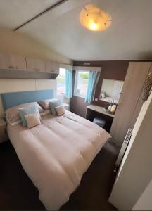 una camera da letto con un grande letto bianco e una scrivania di At The Waters Edge ( Wansbeck View 26 ) a Newbiggin-by-the-Sea