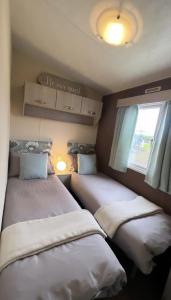 2 camas en una habitación pequeña con ventana en At The Waters Edge ( Wansbeck View 26 ) en Newbiggin-by-the-Sea