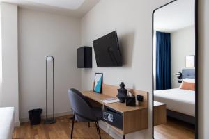 a bedroom with a desk with a bed and a mirror at The Poet Hotel in La Spezia