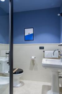 La salle de bains est pourvue de toilettes et d'un lavabo. dans l'établissement The Poet Hotel, à La Spezia