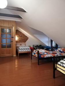 um quarto no sótão com 2 camas e uma porta em Ewa Dom em Varósvia