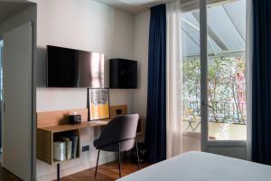 una camera da letto con scrivania, sedia e finestra di The Poet Hotel a La Spezia