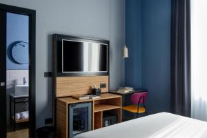a bedroom with a tv and a desk with a chair at The Poet Hotel in La Spezia