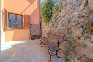 a wooden bench sitting next to a stone wall at [Como-Blevio] Suite lake view + private garage in Blevio