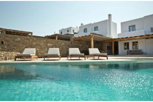 un grupo de sillas sentadas junto a una piscina en Super Luxury Mykonos Villa - Villa La Isla Bonita - Private Gym - Private Pool - 5 Bedrooms - Sea Views en Dexamenes