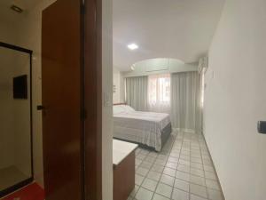a small bedroom with a bed and a bathroom at Pasargada 115 in Vila Velha
