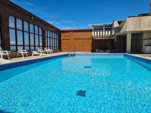 a large pool with blue water in front of a building at Pasargada 115 in Vila Velha +6 photos