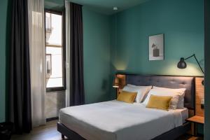 a bedroom with a bed with a blue wall at The Poet Hotel in La Spezia