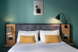 a bedroom with a large bed with two yellow pillows at The Poet Hotel in La Spezia