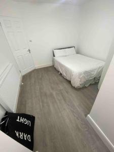 ein kleines Schlafzimmer mit einem Bett in einem Zimmer in der Unterkunft Gladys’ Apartment in Ponders End