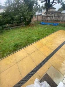 a yard with a patio and a grass yard at Gladys’ Apartment in Ponders End