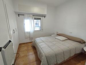 ein weißes Schlafzimmer mit einem Bett und einem Fenster in der Unterkunft Villa rural Valencia in Siete Aguas