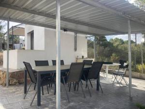 eine Terrasse mit einem Tisch und Stühlen unter einer Pergola in der Unterkunft Villa rural Valencia in Siete Aguas