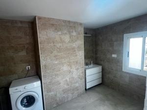 ein Badezimmer mit einer Waschmaschine und einem Waschbecken in der Unterkunft Villa rural Valencia in Siete Aguas