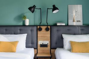a bedroom with two beds and blue walls at The Poet Hotel in La Spezia