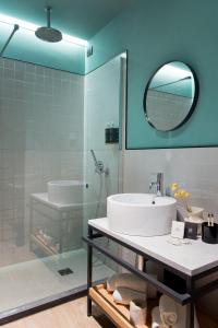 a bathroom with a sink and a tub and a mirror at The Poet Hotel in La Spezia
