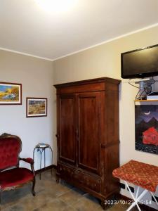 a living room with a tv and a wooden cabinet at La Terrazza del Barbaresco in Neviglie
