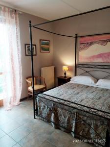 sypialnia z dużym łóżkiem i krzesłem w obiekcie La Terrazza del Barbaresco w mieście Neviglie