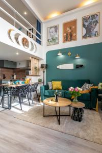 - un salon avec un canapé vert et une table dans l'établissement Calliopée - Magnifique duplex, Gros Horloge Rouen, à Rouen