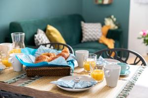 - une table avec un panier de pain et des verres de jus d'orange dans l'établissement Calliopée - Magnifique duplex, Gros Horloge Rouen, à Rouen