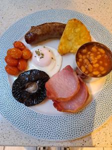 a plate of food with eggs bacon beans and meat at Waterfront House in Dartmouth