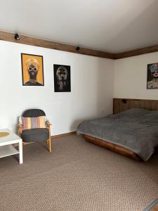 a bedroom with a bed and a chair and pictures on the wall at Гостьовий Дім Guest House in Kotowsk