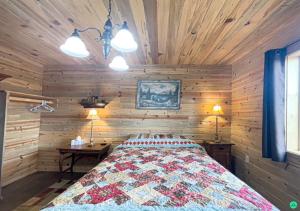 1 dormitorio con 1 cama en una pared de madera en Pinyon View Murdock Cabin en Verdure
