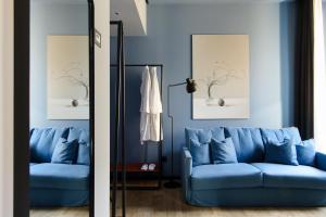 a living room with a blue couch and a mirror at The Poet Hotel in La Spezia