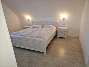 a bedroom with a white bed and two night stands at Ferienwohnung" Julia"in Norden in Norden +8 photos