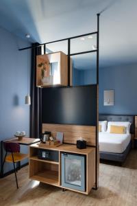 a living room with a tv and a bed at The Poet Hotel in La Spezia