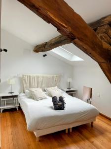 a bedroom with a large white bed with two tables at Les Mirabelles in Tournon-dʼAgenais