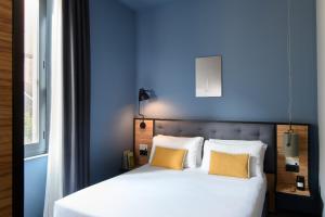 a bedroom with a bed with blue walls and yellow pillows at The Poet Hotel in La Spezia