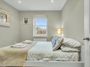 - une chambre blanche avec un lit et une fenêtre dans l'établissement Pass the Keys Beach Front Home, à Whitstable