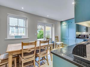 une cuisine avec des armoires bleues, une table et des chaises dans l'établissement Pass the Keys Beach Front Home, à Whitstable